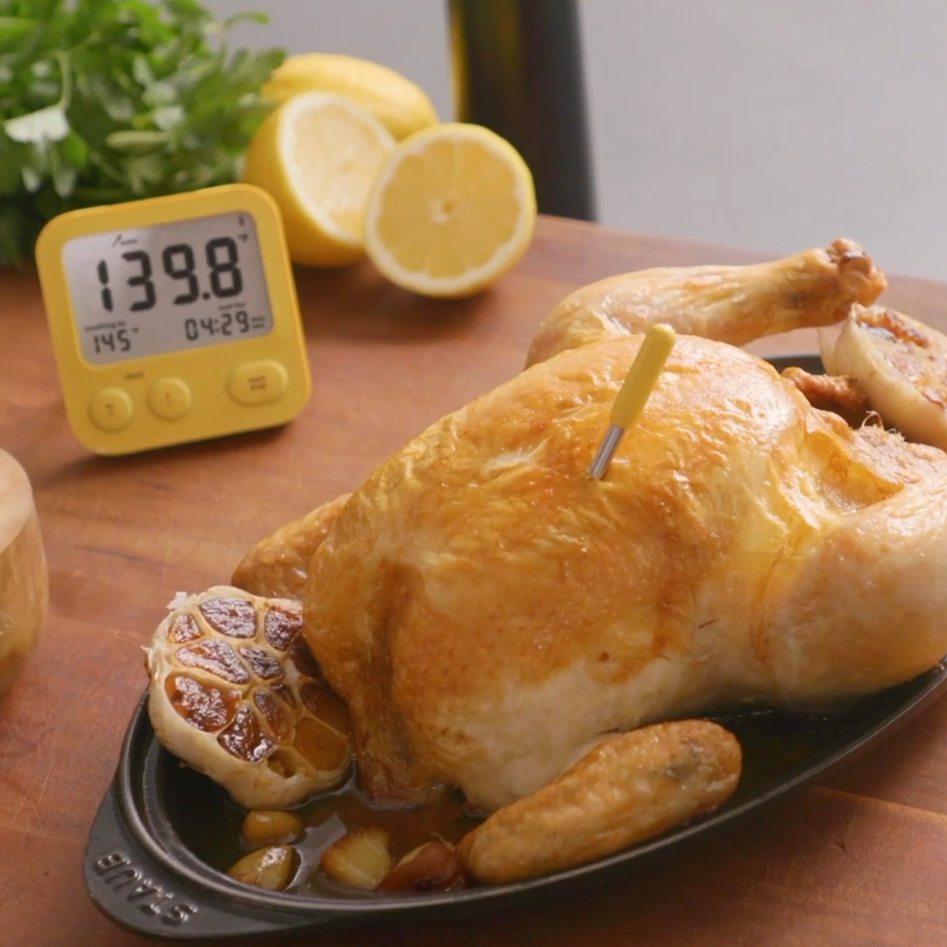 Roast chicken with the Combustion Predictive Thermometer and Display. Display shows core temp, cooking to temp, and ready-in time. Also, there are lemons. 